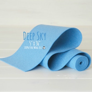 May include: A roll of light blue wool felt, 5 inches by 36 inches, labeled "Deep Sky 5" x 36" 100% Pure Wool Felt".