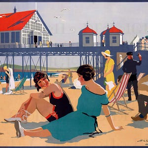 May include: Vintage travel poster depicting a beach scene with a pier, seagulls, and people enjoying the sun. Two women in swimwear and a teal dress sit on the sand. The pier has a red roof and the sky is a light blue.