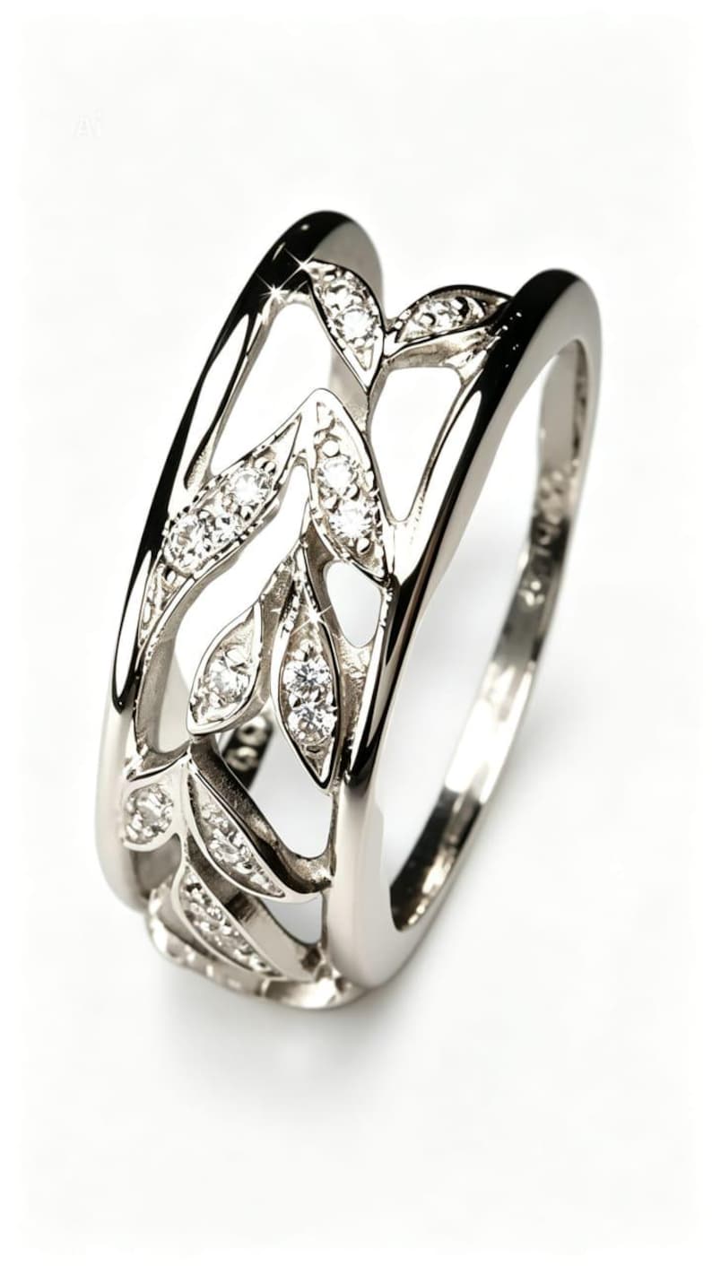Peut inclure: Une bague en argent avec un motif de feuilles. La bague pr&eacute;sente des d&eacute;coupes en forme de feuilles, chacune orn&eacute;e de petites pierres pr&eacute;cieuses scintillantes. L'anneau est lisse et poli, cr&eacute;ant un contraste avec les feuilles textur&eacute;es.