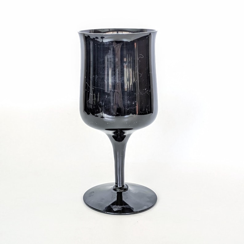 May include: A black glass wine goblet with a tall stem and a wide base.