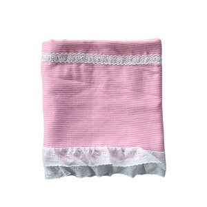 May include: A pink baby blanket with white lace trim. The blanket has a striped pattern.