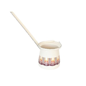 May include: Cream-colored enamel coffee pot with a long handle. The pot features a geometric pattern in shades of brown, orange, and yellow. The spout is designed for easy pouring. A vintage kitchenware item.