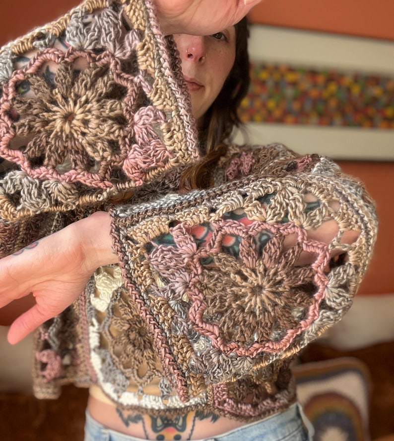 K&ouml;nnte beinhalten: Ein geh&auml;keltes Oberteil in Braun, Rosa und Wei&szlig;. Das Oberteil hat eine lockere Passform und ein Blumenmuster.