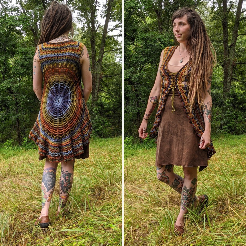 May include: A sleeveless crochet vest featuring a circular web-like pattern in shades of orange, yellow, blue, and brown. The garment has an open front design with a tie closure and a flared, ruffled hemline that extends longer in the back.