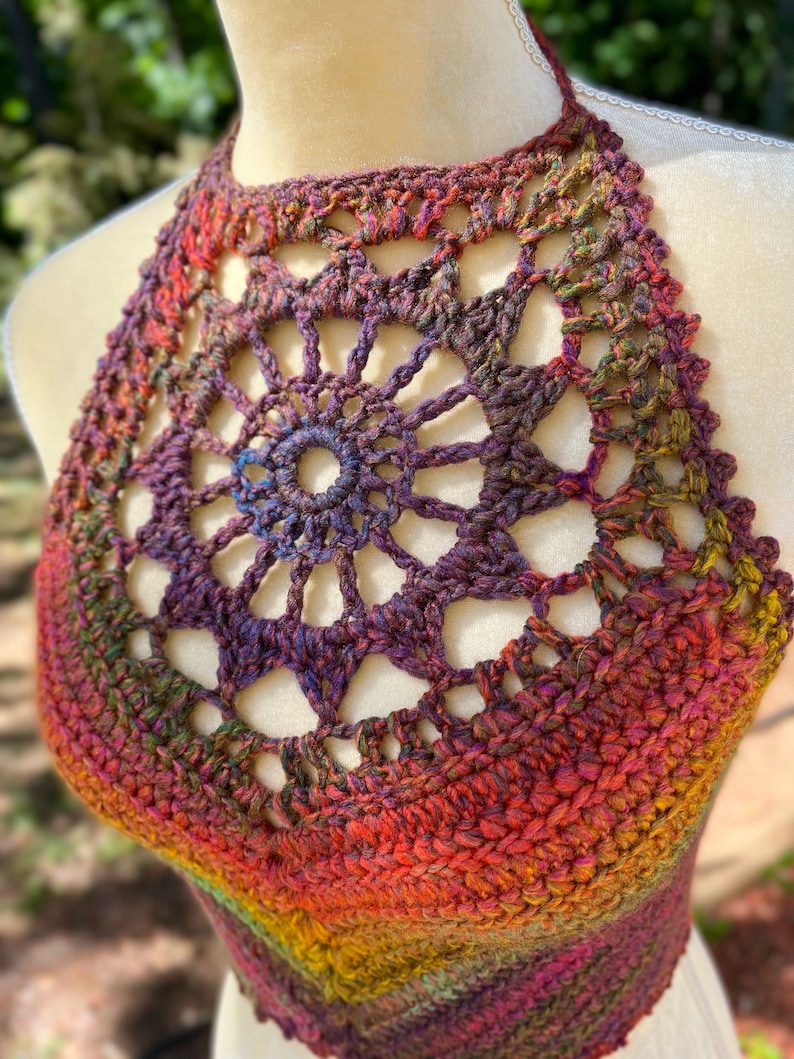 May include: A crocheted halter top with a colorful ombre design in shades of red, orange, yellow, green, purple, and brown. The top features a large, openwork mandala design in the center.