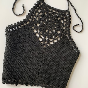Puede incluir: Top de halter negro de crochet con un delicado dise&ntilde;o calado. El top est&aacute; hecho de un hilo suave y ligero y tiene un ajuste holgado.