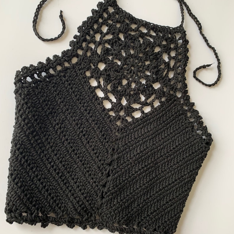 Puede incluir: Top de halter negro de crochet con un delicado dise&ntilde;o calado. El top est&aacute; hecho de un hilo suave y ligero y tiene un ajuste holgado.