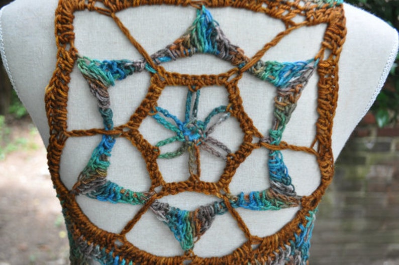 May include: A crocheted vest with a geometric pattern in shades of brown, blue, and green.