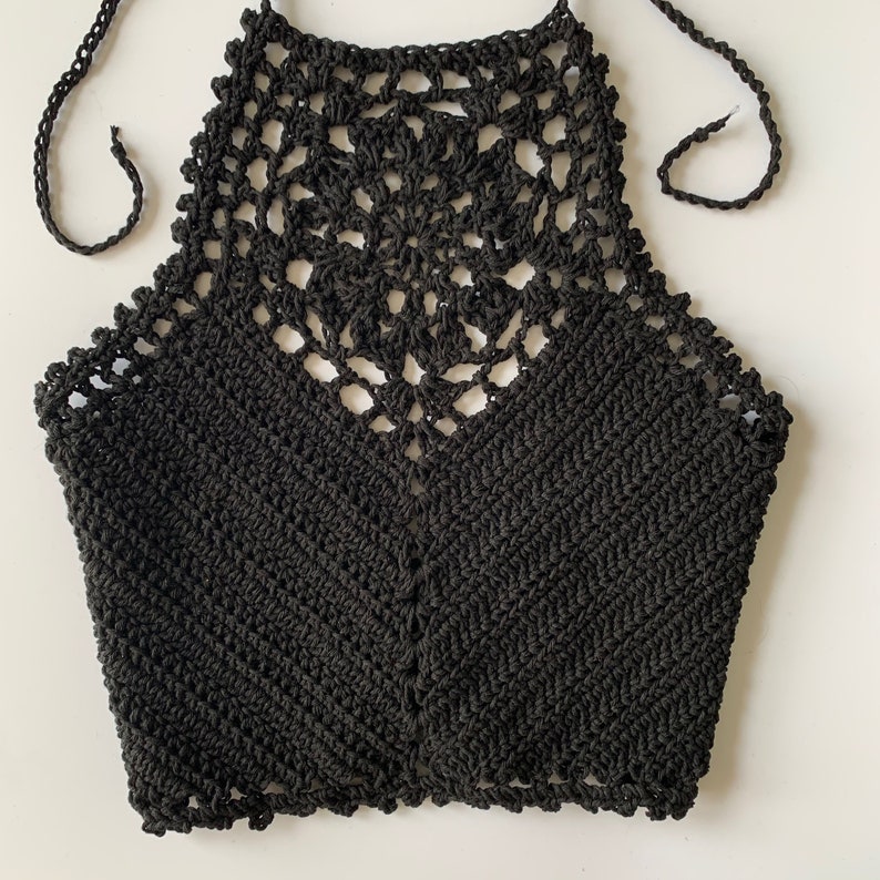 Puede incluir: Top negro de crochet con un delicado patr&oacute;n floral. El top es corto y tiene un estilo de cuello halter.