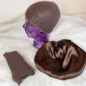 May include: Three brown satin hair accessories. A brown satin bonnet, a brown satin sleep cap, and a brown mesh wig cap.
