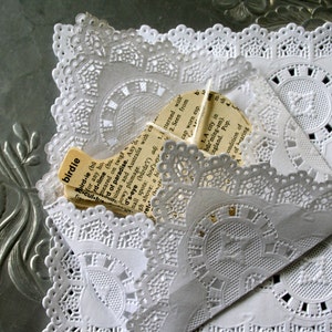 May include: A white doily with a lace pattern and a piece of paper with the word "birdie" and a definition of the word. The paper is partially obscured by the doily.