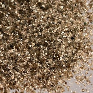 Peut inclure: Gros plan sur un tas de paillettes de mica dor&eacute;es iris&eacute;es. Les paillettes sont petites et de forme irr&eacute;guli&egrave;re, avec une finition m&eacute;tallis&eacute;e chatoyante.