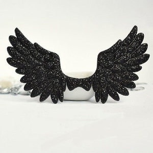 May include: Black glitter angel wings with a feathery design.