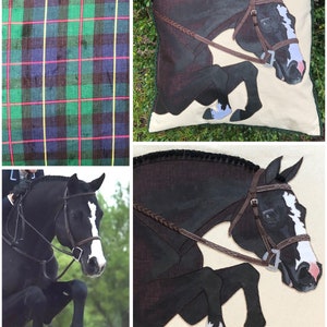 May include: A black and white horse jumping over a fence. The horse is wearing a brown bridle and a braided leather rein. The horse is depicted in a realistic style on a cream-coloured pillow with a green border.