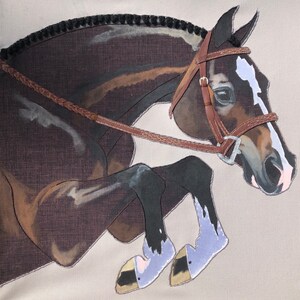 May include: A brown and white horse with a black mane and tail jumps over a fence. The horse is wearing a brown leather bridle with a silver bit.
