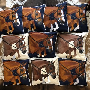 May include: Nine decorative throw pillows featuring a brown and white horse design. The pillows have a navy blue background and white trim.