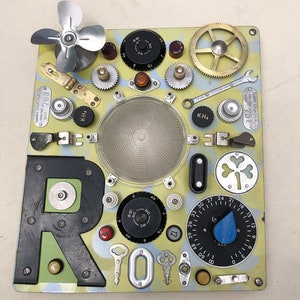 May include: A yellow and blue background with a black letter R, a variety of metal gears, keys, and other objects. The text "SURRY COUNTY N.C. 008 TAX 1331 763" and "SURRY COUNTY.N.C. COD TAX 7519" are visible on the background.