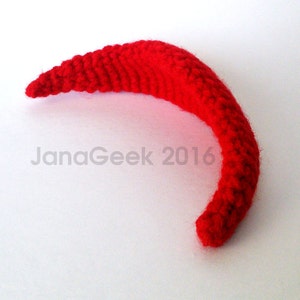 May include: A red crocheted headband in the shape of a crescent moon.