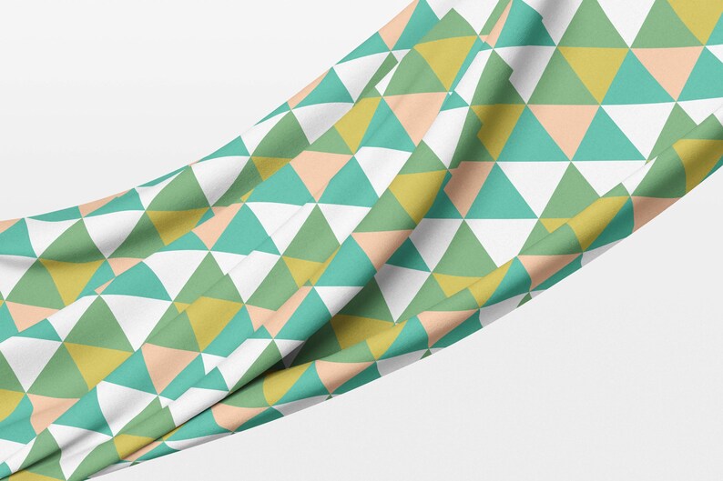 May include: A fabric with a geometric pattern of green, yellow, peach, and white triangles.