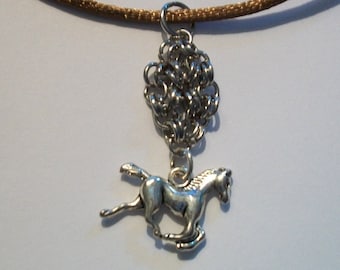 May include: A silver horse charm pendant hangs from a brown cord necklace. The horse is running and has a detailed design. The pendant is attached to a silver chain link.