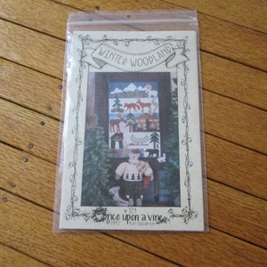 May include: A quilting pattern titled "Winter Woodland" with a picture of a winter scene and the text "Once Upon a Vine" and "1997, Kim Woodrich".