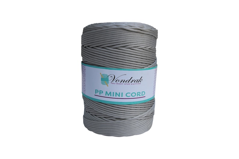 Puede incluir: Una bobina de hilo gris PP Mini Cord de Vondrak. El cord&oacute;n est&aacute; bien enrollado y tiene un aspecto texturizado. La etiqueta es blanca con detalles turquesa y morados y el texto "Vondrak" y "PP MINI CORD".