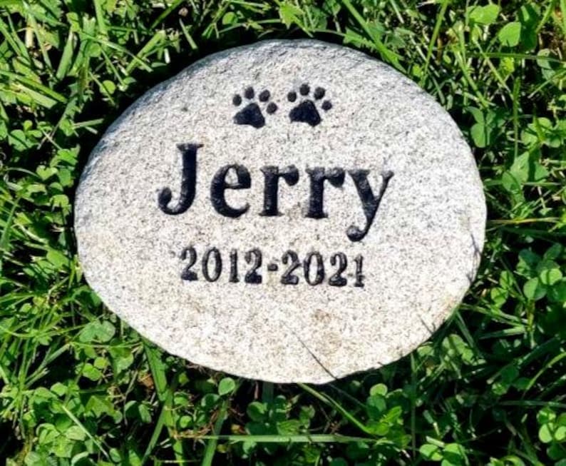 May include: A gray stone memorial with two paw prints and the inscription "Jerry 2012-2021".