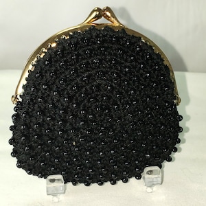May include: A black beaded coin purse with a gold clasp.