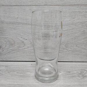 以下が含まれることがあります： 丸みを帯びた底とわずかに広がった上部を備えた、透明な背の高いパイントグラス。 グラスは滑らかな表面で、側面に小さなロゴが付いています。 ビールを提供するように設計されています。