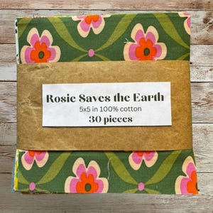 May include: A stack of 30 pieces of 12.7 x 12.7 cm 100% cotton fabric squares wrapped in a brown paper band. The fabric features a repeating pattern of pink and orange flowers on a dark green background. The label reads Rosie Saves the Earth.