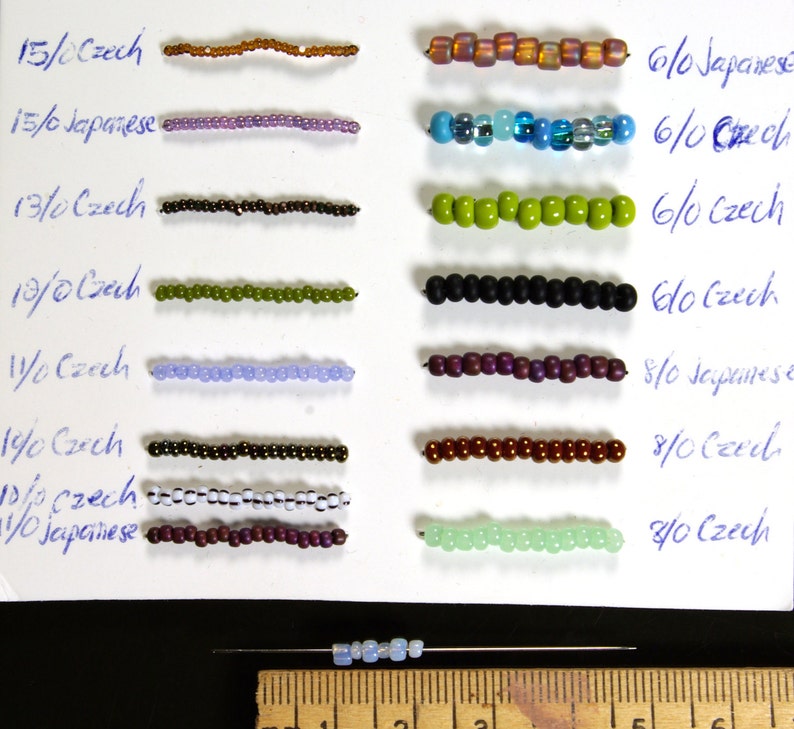 May include: A white card with rows of different colored beads. The beads are labeled with their size and type, such as 15/0 Czech, 6/0 Japanese, and 8/0 Czech. The card also includes a ruler for measuring the beads.
