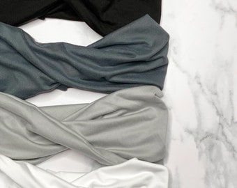Fasce per capelli extra larghe intrecciate nei toni neutri del nero, del bianco e del grigio.