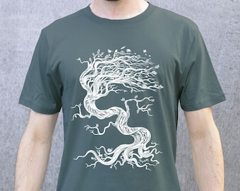 Può includere: Una maglietta verde scuro con una grafica bianca di un albero con intricati rami e radici. L'albero è stilizzato con testo incorporato nei rami e nelle radici.