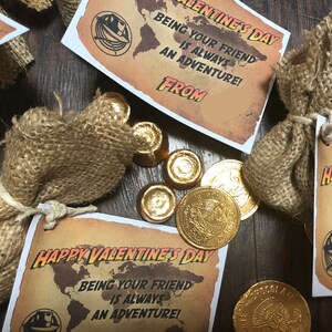 May include: A set of Valentine's Day gifts featuring small burlap bags filled with chocolate gold coins and a printed card that reads "Happy Valentine's Day, Being your friend is always an adventure!"