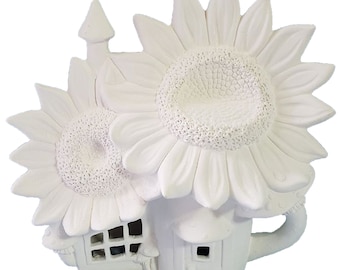 May include: A white ceramic fairy house with two large sunflower roofs. The house has a small chimney, windows, and a door. The design is whimsical and detailed, perfect for garden decor or a unique gift.