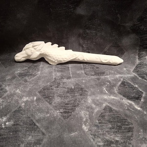 May include: White ceramic dragon head pipe. The dragon has detailed scales and a long snout.