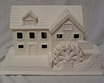May include: A ceramic water mill figurine, unpainted and ready for customization. The structure features a detailed roof, windows, and a prominent water wheel. The piece is designed to be painted and personalized.