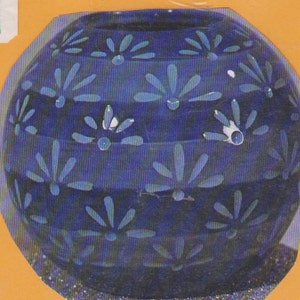 May include: A blue ceramic vase with a white floral pattern. The vase has a round shape and a smooth, glossy finish.