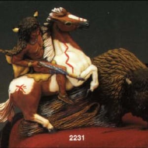 May include: A detailed figurine depicting a Native American on horseback, alongside a bison. The horse is painted white and brown with a red lightning bolt design. The Native American figure is adorned with feathers and traditional attire. The bison is dark brown.