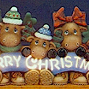 May include: Four brown moose figurines with antlers, wearing hats and scarves, holding a blue banner that reads "Merry Christmas".