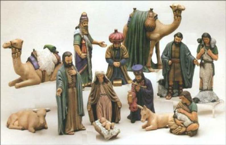 May include: A detailed nativity scene set featuring multiple figurines. The set includes figures of the three wise men, camels, and other biblical characters. The figurines are painted in various colors and are arranged to depict the traditional Christmas story.