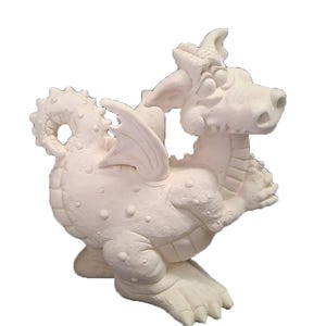 May include: A white ceramic dragon figurine with a detailed design. The dragon has wings, horns, and a textured body with small bumps. The figurine is posed in a sitting position, with its front paws extended.