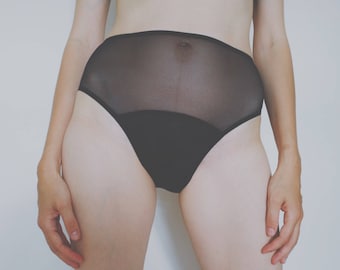 Puede incluir: Ropa interior negra transparente de cintura alta con una banda negra.