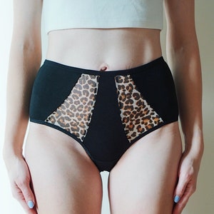 Omarm stijl en comfort met ons chique zwarte katoenen slipje met luipaardprintaccenten en inzetstukken van mesh. Alle maten.