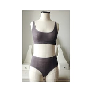 May include: A gray bra and underwear set made of a soft, comfortable fabric. The bra has a scoop neck and a racerback style. The underwear has a high waist and a full coverage style.