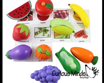 May include: A set of nine colorful, soft, textured, foam fruits and vegetables with corresponding picture cards. The set includes a red apple, a green watermelon slice, a red strawberry, a green pea pod, a yellow corn cob, an orange carrot, a purple eggplant, an orange pumpkin, and a purple bunch of grapes.