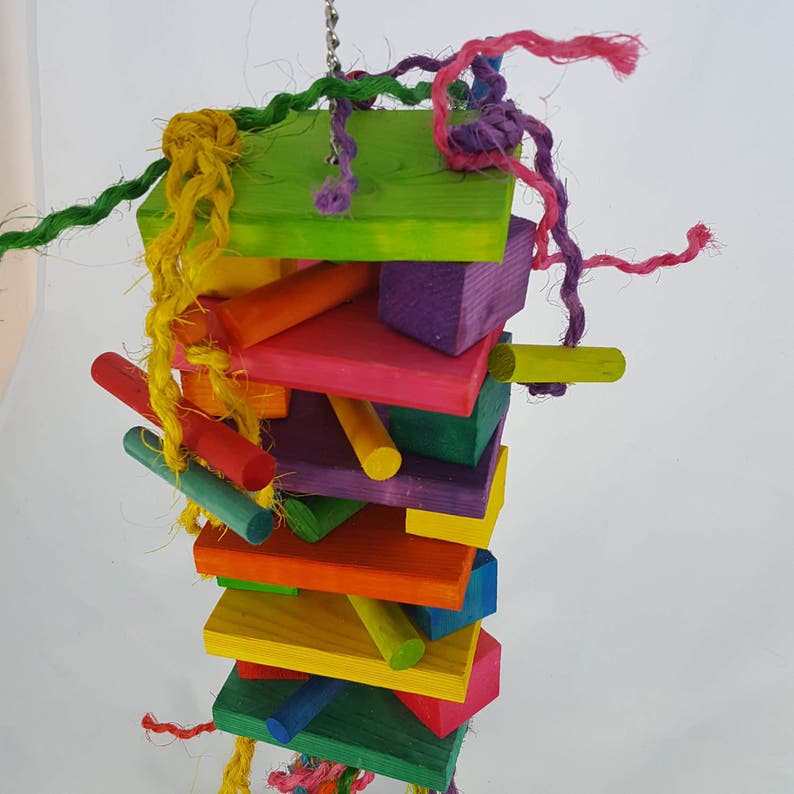 May include: A colorful wooden bird toy with multiple shapes and sizes, strung together with natural rope and colorful yarn. The toy is designed for birds to chew and play with.