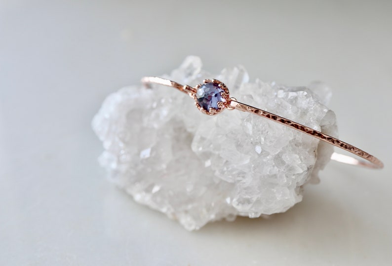 Pode incluir: Um delicado bracelete de ouro rosa com uma pequena gema redonda de cor p&uacute;rpura engastada.