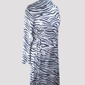 May include: A white and black zebra print long-sleeved dress with a tie at the waist.