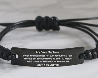 May include: Black adjustable bracelet with a black metal tag that reads "My Dear Nephew I Wish You Happiness Not Just Because It's Your Birthday But Because I Love To See You Happy. More Smiles To Your Face All Year Round Love You, Auntie"